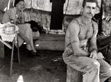 Unemployed lumber worker goes with his wife to the bean harvest. Note Social Security number tattooed on his arm.
