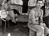 Thomas Cave, 27 year old unemployed lumber worker, and his wife resting after working a bean harvest in 1939 Oregon. Notice his tattoo of his social security number. Photo taken by Dorothea Lange.