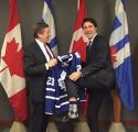 Tory presents Trudeau with a Leafs jersey, as Trudeau shows off his Habs socks