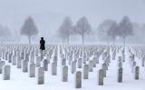 Lone figure in cemetery during snowstorm