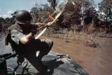 Lt. Commander Donald D. Sheppard, USN, of Coronado, California, aims a flaming arrow at a bamboo hut concealing a fortified Viet Cong bunker on the banks of the Bassac River, Vietnam on December 8, 1967.