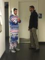 He is having a serious conversation with a guy in a onesie.