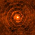 The highly regular spirals of gaseous material surrounding the binary star system LL Pegasi.
