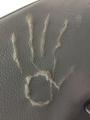 This hand...mark on the back of a bus seat.