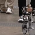 Remote controlled robot rides a bicycle.