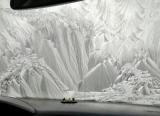 The frost on the windshield looks like a winter wonderland scene