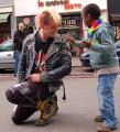 A punk stops during a gay pride parade to allow a mesmerized child to touch his jacket spikes.