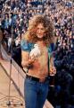 Robert Plant of Led Zeppelin holding a dove that flew into his hand while on stage, 1973.